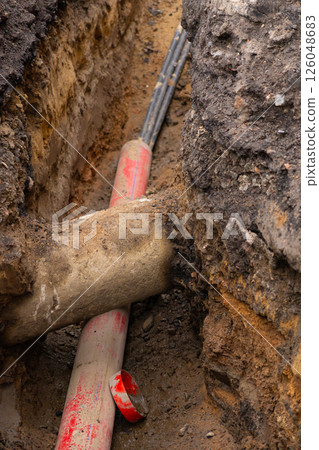 Repair of sewage heating systems or electricity. A trench has been dug in the ground. 126048683