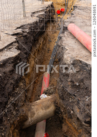 Repair of sewage heating systems or electricity. A trench has been dug in the ground. 126048691