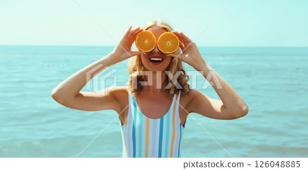 Summer, happy smiling young woman, laughing, with fruits, having fun on the beach on sea background Summer, happy smiling young woman, laughing, with fruits, having fun on the beach on sea background 126048885