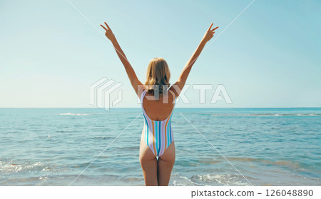 Summer vacation, beautiful happy woman in swimsuit raising her hands up on the beach at sea 126048890