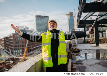 Engineer with open arms at construction site. 126049393