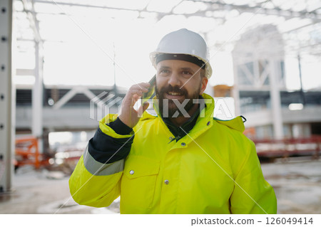 Portrait of construction foreman making phone call in modern building site. 126049414