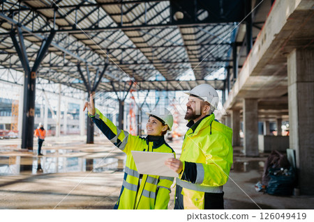 Engineers discussing construction plans using a tablet on site. 126049419