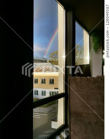 Colorful rainbow visible through a window after rain, with soft reflections on the glass. Symbol of hope, inspiration, and emotional clarity Colorful rainbow visible through a window after rain, with soft reflections on the glass. Symbol of hope, inspiration, and emotional clarity 126049587