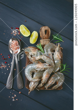 Fresh raw, white-footed shrimp, tiger prawns vannamei, on a wooden cutting board, with lime slices, and seasonings, Fresh raw, white-footed shrimp, tiger prawns vannamei, on a wooden cutting board, with lime slices, and seasonings, 126049905