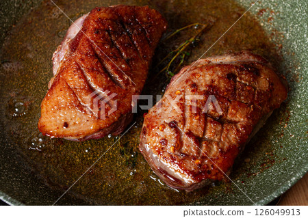 cooking duck breast, in a frying pan, fried, with spices and herbs, close-up, no people, 126049913