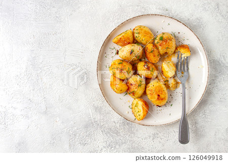 half-eaten fried new potatoes, with butter and dill, on a white plate, with a fork, at home, no people, 126049918