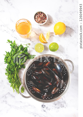 Fresh mussels, in a metal colander, with ingredients on the table, light background, no people, Fresh mussels, in a metal colander, with ingredients on the table, light background, no people, 126049943