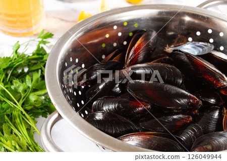Fresh mussels, in a metal colander, with ingredients on the table, light background, no people, Fresh mussels, in a metal colander, with ingredients on the table, light background, no people, 126049944