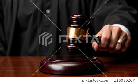 Judge's gavel striking sound block in a courtroom ruling Judge's gavel striking sound block in a courtroom ruling 126050207