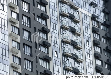 A very tall building featuring numerous windows and multiple balconies A very tall building featuring numerous windows and multiple balconies 126050583