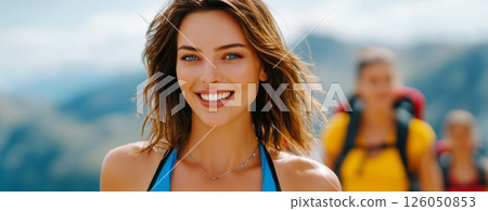 Smiling Woman Enjoys Hiking With Friends in Breathtaking Mountain Landscape on a Sunny Day 126050853