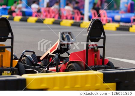 Red Go-kart sports action. Drivers gear up for a high-speed go kart race, ready to compete on the outdoor motorsport track. Red Go-kart sports action. Drivers gear up for a high-speed go kart race, ready to compete on the outdoor motorsport track. 126051530
