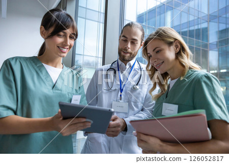 Team of young doctors discussing something and looking interested and involved 126052817