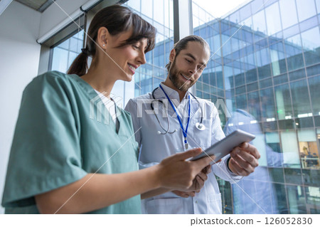 Two doctors discussing an interesting case while walking in the clinic corridor 126052830