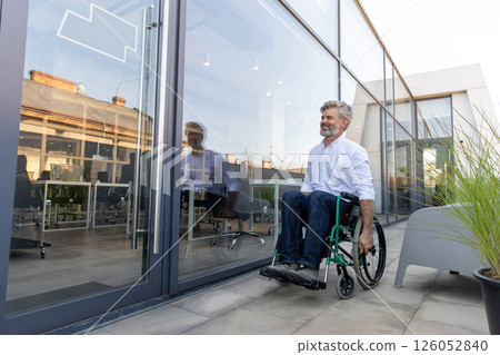 Mature man on a wheelchair looking determined and confident Mature man on a wheelchair looking determined and confident 126052840