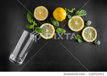 Fresh juicy lemon and mint leaves on black background. Ingredients for summer cocktail. Food background. Advertising concept of refreshing drink. Copy space. Fresh juicy lemon and mint leaves on black background. Ingredients for summer cocktail. Food background. Advertising concept of refreshing drink. Copy space. 126052852