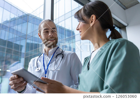 Doctors discussing an interesting case and looking involved 126053060