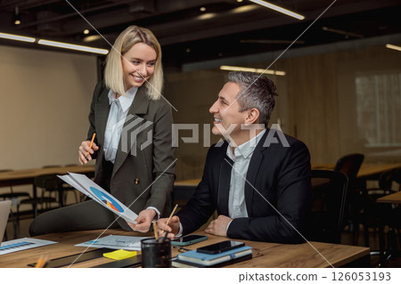 Two colleagues discussing project details and feeling positive 126053193