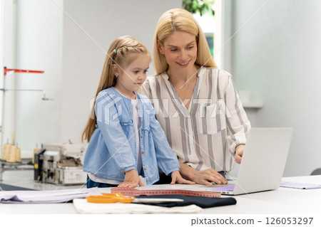 Pretty young caucasian woman in her design studio with her daughter 126053297
