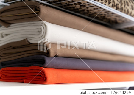 Colorful piles of fabric one on one on the shelf Colorful piles of fabric one on one on the shelf 126053299