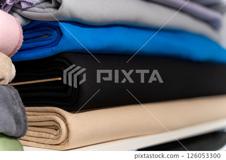 Colorful piles of fabric one on one on the shelf Colorful piles of fabric one on one on the shelf 126053300