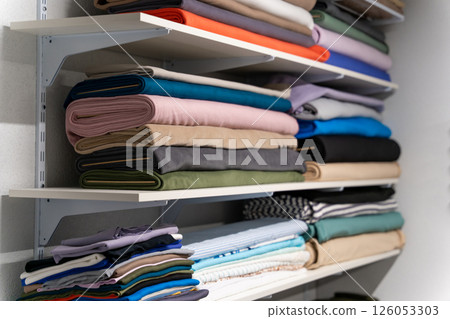 Colorful piles of fabric one on one on the shelf Colorful piles of fabric one on one on the shelf 126053303