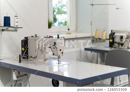 Dress designer studio with sewing equipment and table in the middle Dress designer studio with sewing equipment and table in the middle 126053309