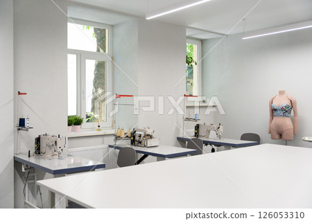 Dress designer studio with sewing equipment and table in the middle Dress designer studio with sewing equipment and table in the middle 126053310