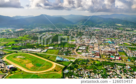 Aerial view of Arima, a town in Trinidad and Tobago, with the Northern Range mountains in the background and a horse racing track visible in the foreground. Aerial view of Arima, a town in Trinidad and Tobago, with the Northern Range mountains in the background and a horse racing track visible in the foreground. 126053457