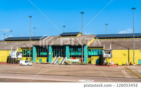 Terminal building of Piarco International Airport near Port of Spain, Trinidad and Tobago, viewed from the tarmac under a clear blue sky. 126053458