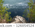 Rocky Cliff Above Frozen Lake with Pine Trees in Early Spring 126054524