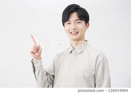 20 多歲的男子指著左邊，白色背景 126054904