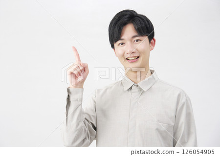 20 多歲的男子指著左邊，白色背景 126054905