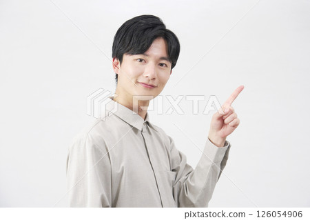 Man in his 20s pointing to the right, white background 126054906