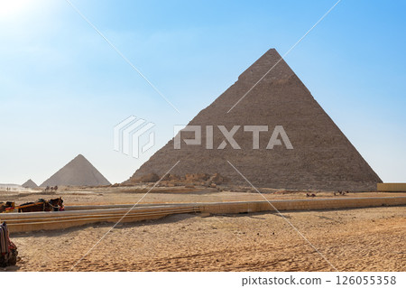 Stunning view of the Great Pyramids of Giza in the desert under a clear blue sky during the daytime Stunning view of the Great Pyramids of Giza in the desert under a clear blue sky during the daytime 126055358