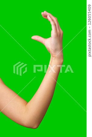 Hand gesture demonstrating the symbol of good luck on a bright green background 126055409