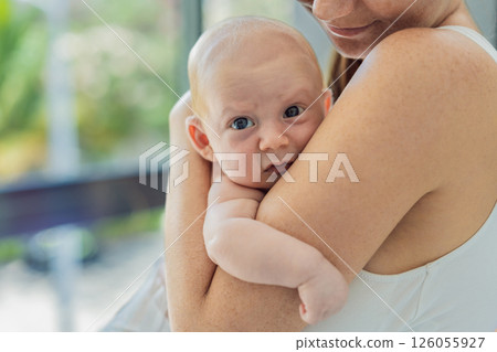 Mother gently hugging her baby at home, sharing a warm and loving moment. Parenthood, family bonding, and maternal love concept Mother gently hugging her baby at home, sharing a warm and loving moment. Parenthood, family bonding, and maternal love concept 126055927