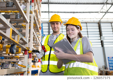 Male and Female worker inspect goods auto parts on shelves in warehouse. logistic import export auto parts. Checklist stock product in storage for logistic. 126057375