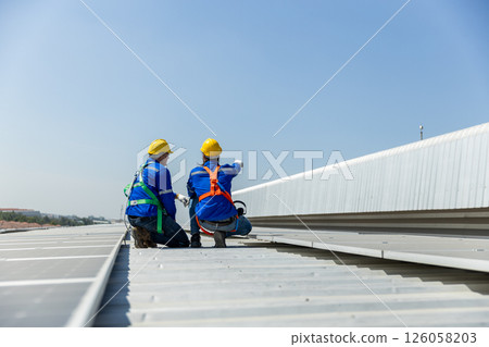 Man worker set installation and inspection standards of solar panels on roof of an industrial factory. Team technician inspection solar cell. Alternative innovation power environmental 126058203