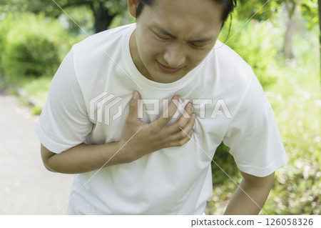 Young man holding his chest while running, heart attack, myocardial infarction Young man holding his chest while running, heart attack, myocardial infarction 126058326