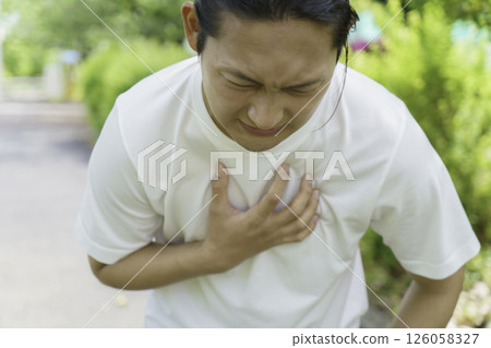 Young man holding his chest while running, heart attack, myocardial infarction Young man holding his chest while running, heart attack, myocardial infarction 126058327