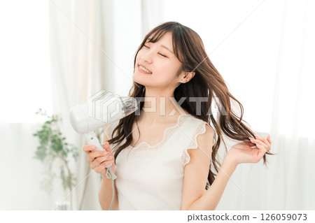女人用吹風機吹乾頭髮（護髮） 126059073