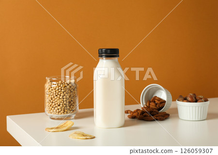 Bottle of alternative milk, nuts and soybeans on brown background Bottle of alternative milk, nuts and soybeans on brown background 126059307
