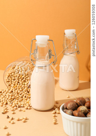 Bottles of alternative milk, nuts and soybeans on orange background Bottles of alternative milk, nuts and soybeans on orange background 126059308