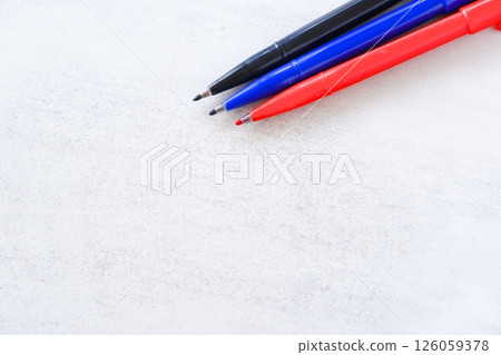 Three pens, blue, red and black, on a desk Three pens, blue, red and black, on a desk 126059378