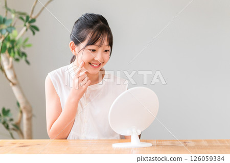 Elementary school and junior high school girls looking in the mirror (skin care, acne) Elementary school and junior high school girls looking in the mirror (skin care, acne) 126059384