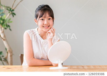 Elementary school and junior high school girls looking in the mirror (skin care, acne) Elementary school and junior high school girls looking in the mirror (skin care, acne) 126059386
