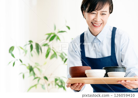 Middle-aged woman serving food Middle-aged woman serving food 126059410