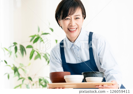 Middle-aged woman serving food Middle-aged woman serving food 126059411